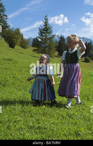 Bergwiese Mädchen läuft zwei Dirndel fröhlich Serie Leute Kinder 1 Jahr 5 Jahre Blond offiziellen dress Geschwister Stockfoto