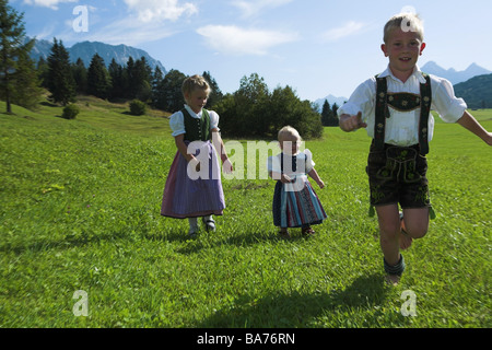 Bergwiese Mädchen zwei junge offizielle Kleid läuft fröhlich Serie Leute Kinder 1 Jahre 5 Jahre blond Dirndel Leder Stockfoto