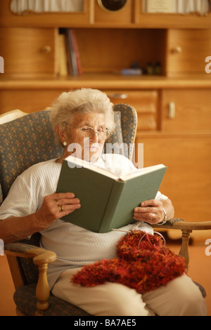 Wohnzimmern senior Stühlen sitzt Buch liest, Detail-Serie Senioren Frau 70-80 Jahre grauhaarige weißhaarige stricken Leute Stockfoto