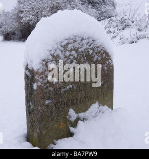 März Schneesturm deckt dieser Meilenstein auf dem Weg von Corfe Castle, Cocknowle auf der Isle of Purbeck, Dorset. Stockfoto