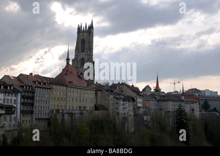 Typische Gebäude, unterstützt durch die gotische Turm der Kathedrale des Heiligen Nikolaus, Fribourg, Schweiz Stockfoto