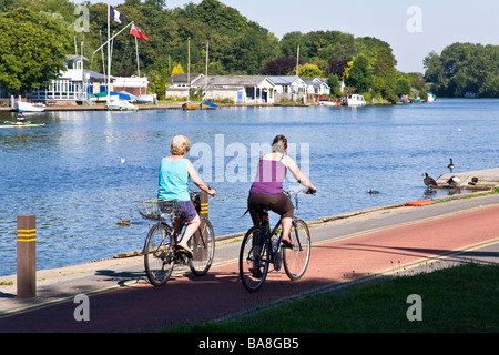 Weibliche Radfahrer genießen die Aussicht auf den Fluss von der Themse Radweg ein paar hundert Yards flussabwärts von Kingston Bridge