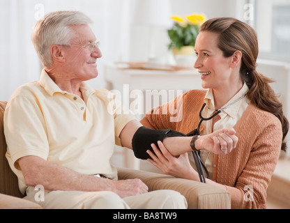 Krankenschwester, die senior woman Blutdruckmessung Stockfoto