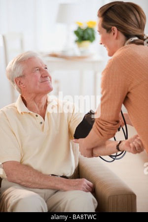 Krankenschwester, die senior woman Blutdruckmessung Stockfoto