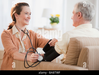 Krankenschwester, die senior woman Blutdruckmessung Stockfoto