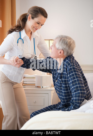 Krankenschwester, die älteren Menschen aus Menschen helfen Stockfoto