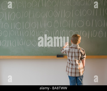 Junge Binärcode an Tafel schreiben Stockfoto