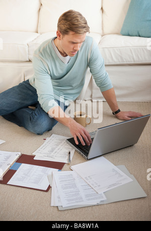 Mann arbeitet am Laptop im Wohnzimmer Stockfoto