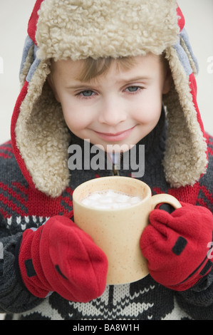 Junge in warme Mütze trinken heißen Schokolade Stockfoto