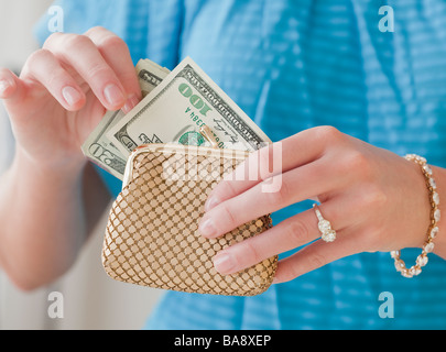 Frau, die Geld aus dem Portemonnaie ziehen Stockfoto