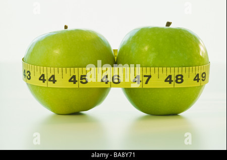 Äpfel in Maßband gewickelt Stockfoto