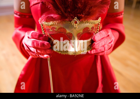 Nahaufnahme eines Weibes behandschuhten Hände halten eine Maske Stockfoto