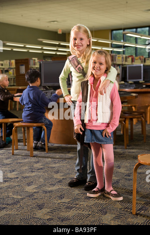 Porträt von zwei Mädchen der Grundschule in Bibliothek Stockfoto