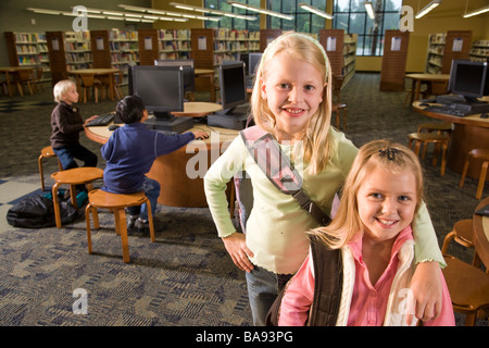 Porträt von zwei Mädchen der Grundschule in Bibliothek Stockfoto