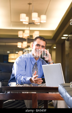 Geschäftsmann, sitzen in der Hotel-Lobby mit Handy Stockfoto