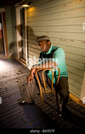 Porträt des afroamerikanischen Mann sitzt auf der Veranda des Hauses in der Nacht Stockfoto