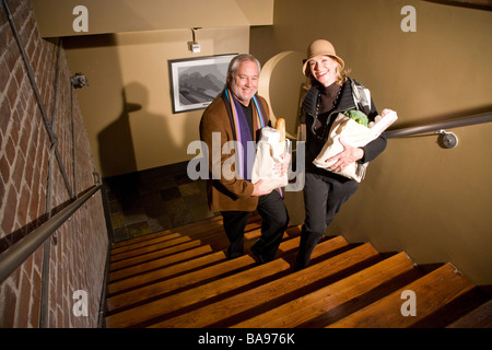Paar mittleren Alters Treppensteigen tragen Einkaufstüten Stockfoto