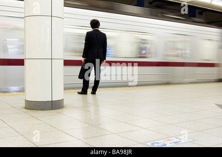 Japanischer Geschäftsmann wartet auf seinen Zug in Tokio Stockfoto