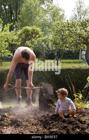 Vater und Sohn Graben am grünen Gemüsegarten für Bio-selbst angebautem Gemüse zu Hause London England UK Stockfoto