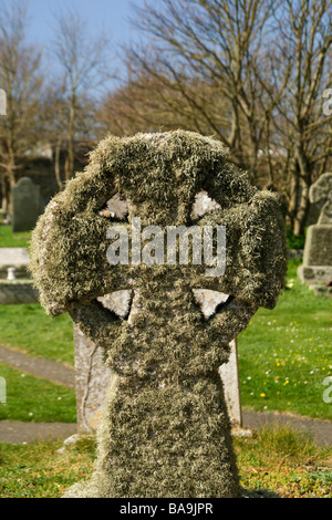 Malteser Kreuz Grabstein in Moos bedeckt Stockfoto