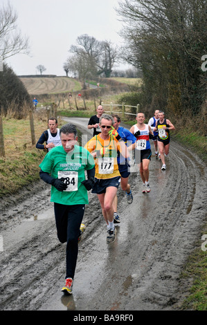 Männer, die auf schlammigen Strecke im Wettbewerb im 10. große Osten laufen gehalten in Bungay Suffolk 2009 Stockfoto