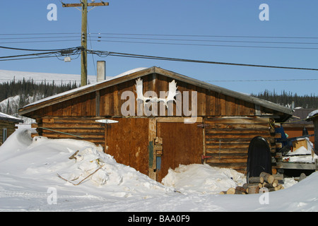 Ein Blockhaus im Schnee in der abgelegenen einfliegen First Nation Ortschaft Old Crow, Yukon Territorium, Kanada. Stockfoto