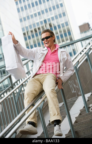 Mann am Geländer hält eine Tasche in der Hand, Stockholm, Schweden. Stockfoto