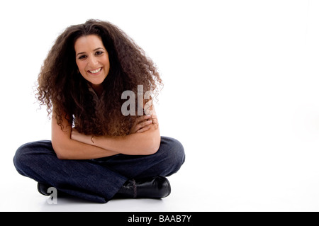 lächelnde Frau, die auf dem Boden sitzend Stockfoto