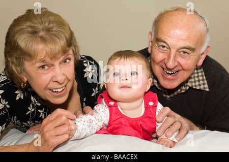 Horizontale nahe Porträt der stolze Großeltern mit ihren niedlichen Baby-Enkelin Stockfoto