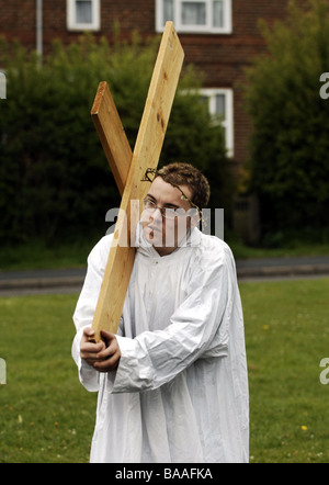 Ein Teenager trägt ein Kreuz auf seinen Schultern, als er die Rolle des Jesus in eine Re-Inszenierung des Dienstes die Passion am Karfreitag Stockfoto