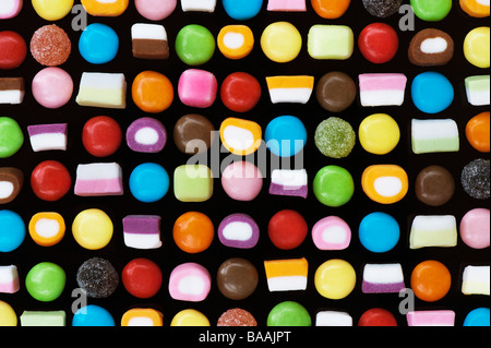Mehrfarbige dolly Mischungen und smarties Süßigkeiten Muster auf Schwarz Stockfoto