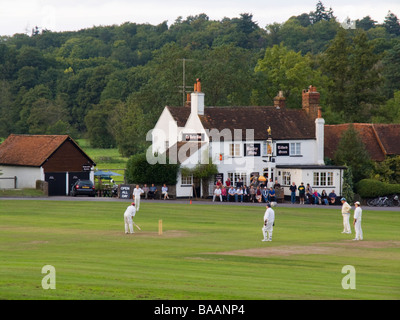 Spielen Kricket auf ein Dorf Grün außerhalb der Gerste land Mähen Pub im Sommer. Tilford Surrey England Großbritannien Großbritannien Stockfoto