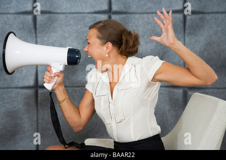 Eine Frau schrie in ein Megaphon in einem Büro, Schweden. Stockfoto