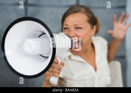 Eine Frau schrie in ein Megaphon in einem Büro, Schweden. Stockfoto