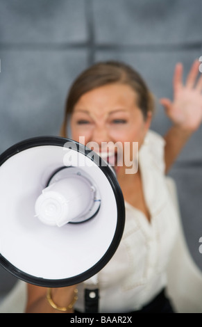 Eine Frau schrie in ein Megaphon in einem Büro, Schweden. Stockfoto