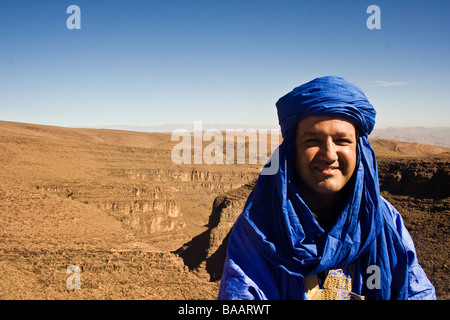 Ein marokkanische Mann gekleidet in traditionellen Indigo Kleidung vor dem Atlas-Gebirge. Stockfoto