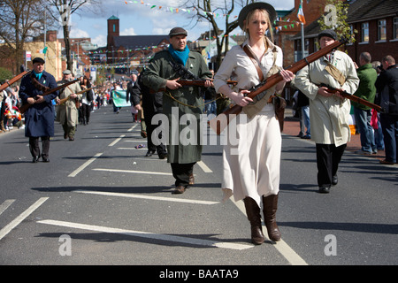 Reinaktoren in historischen Kostümen, die eine fliegende Säule der IRA darstellen Marschieren am Ostersonntag bei der Osteraufstands-Rallye fällt Straße West belfast Stockfoto