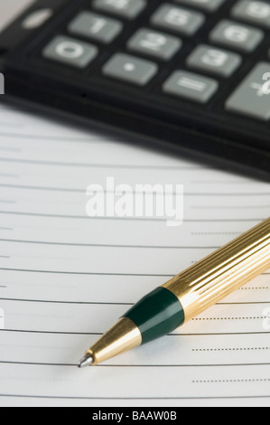 Nahaufnahme eines Kugelschreibers mit Papier und Taschenrechner Stockfoto