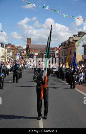 Fahne mit Farbe Partei Marsch entlang der Straße fällt am Ostersonntag während Easter Rising Gedenken fällt weg Belfast Stockfoto