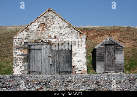 Anzeigen der alten steinernen und hölzernen Schuppen am Strand auf der Heiligen Insel Stockfoto