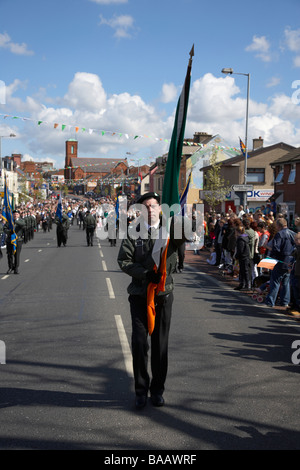 Fahne mit Farbe Partei Marsch entlang der Straße fällt am Ostersonntag während Easter Rising Gedenken fällt weg Belfast Stockfoto