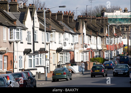 Verkehr und geparkte Autos auf einem Vorort Straße in Lewisham London England Stockfoto