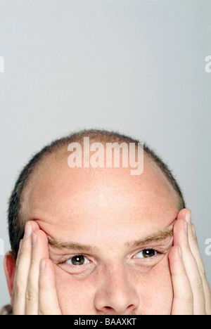 Mann, der sein Gesicht in seinen Händen hält Stockfoto