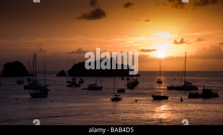 Sonnenuntergang hinter kleine Boote vor Anker vor Gustavia Hafen St. Barts Stockfoto