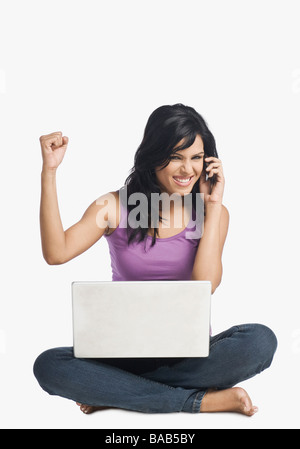 Frau telefonieren mit einem Handy und ballte die Faust Stockfoto