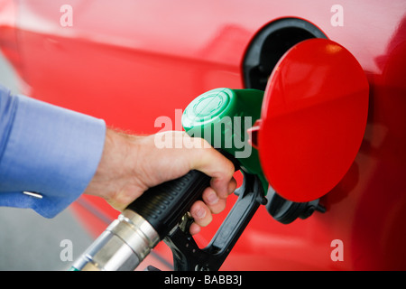 Ein Mann immer Benzin in seinem roten Auto Schweden. Stockfoto