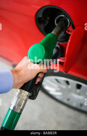 Ein Mann immer Benzin in seinem roten Auto Schweden. Stockfoto