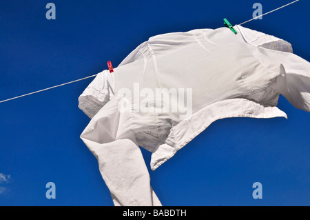 Weißes Hemd hängen zum Trocknen auf der Wäscheleine Stockfoto