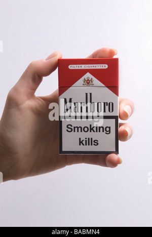 Zarte Frauenhand hält eine Packung Marlboro Rot auf einem weißen Hintergrund Stockfoto