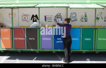 Junge Frau, die recycling-Kartons an mobile recycling-Einheit in Torremolinos Malaga Spanien Stockfoto